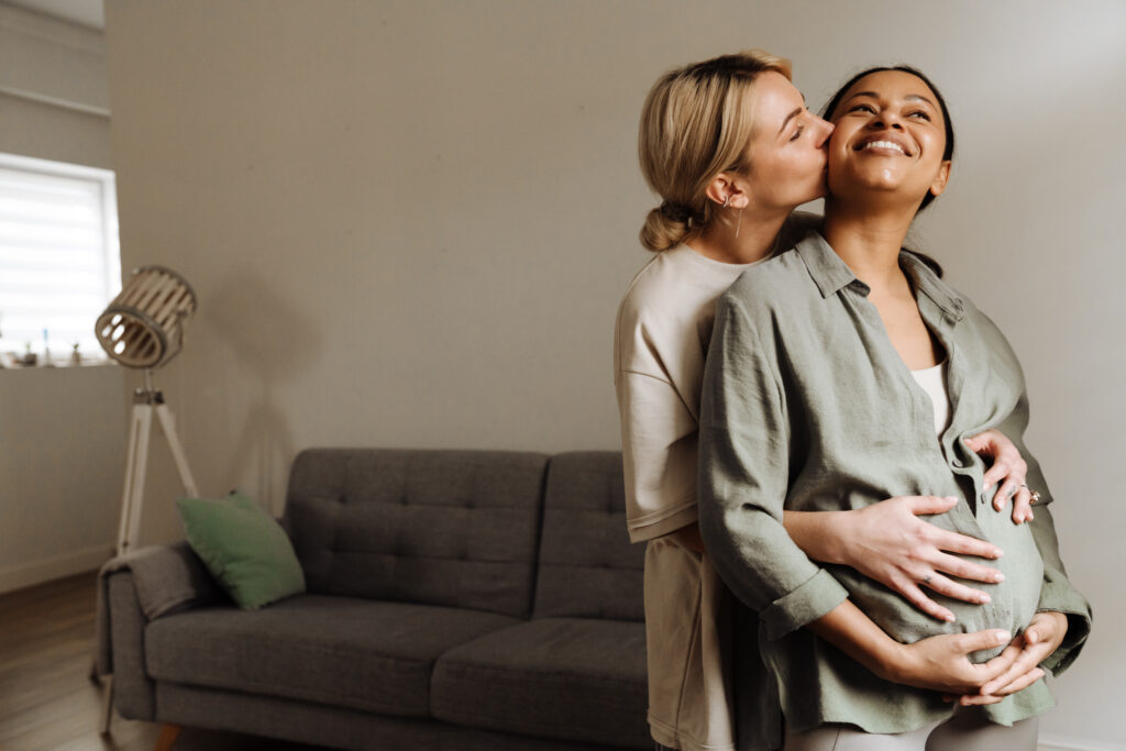 Zwei Frauen, die sich in einem Wohnzimmer herzlich umarmen